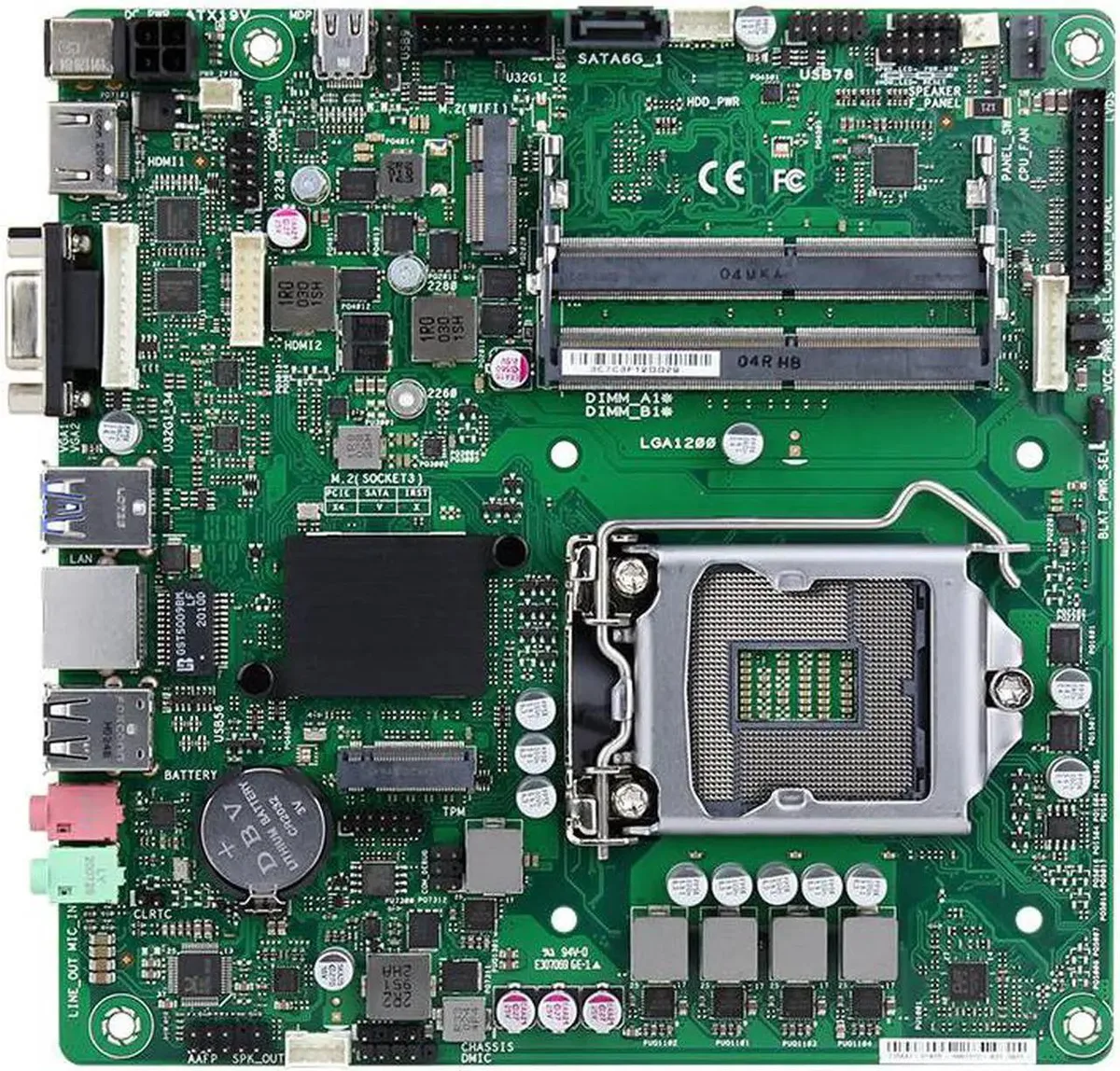 Small square green circuit board with silver CPU socket and black memory slots, metal I/O shield included