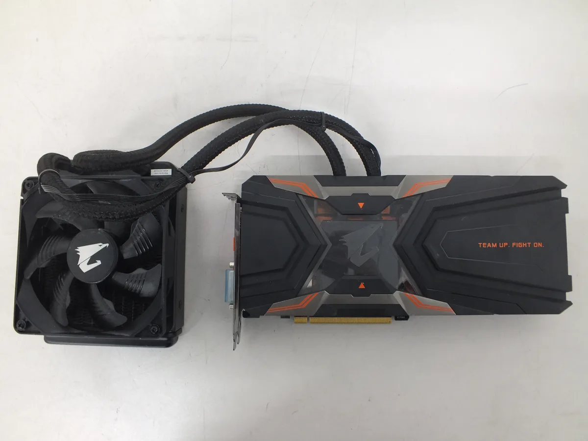 Full-cover waterblock graphics card with metallic silver finish and integrated tubing connectors