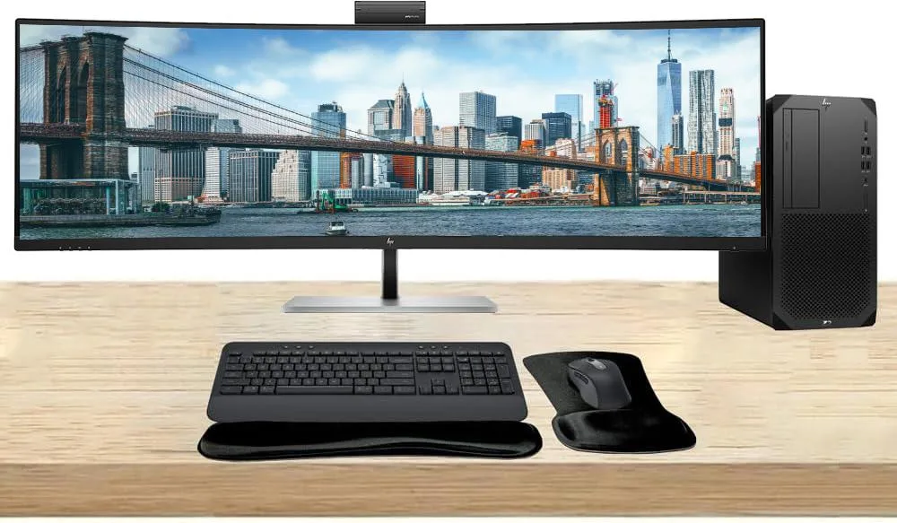 A black HP Z2 G9 tower workstation beside a 49 inch curved ultrawide monitor with a wireless keyboard and mouse combo