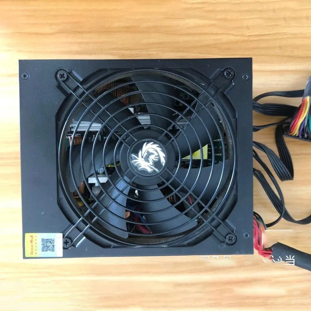Rectangular silver ATX power supply unit with black mesh grille and multiple cable connectors visible