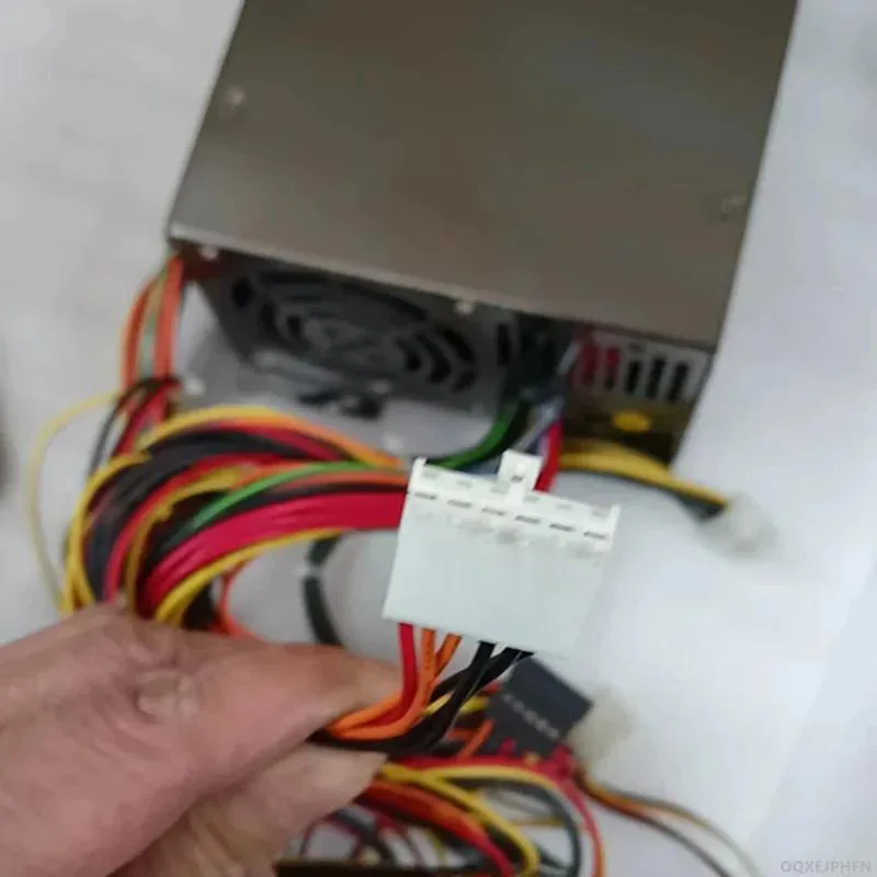 Rectangular black ATX power supply unit with cooling fan and cable bundle
