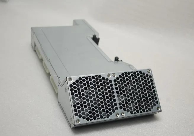 Silver rectangular metal power supply unit with fan grille and connector sockets