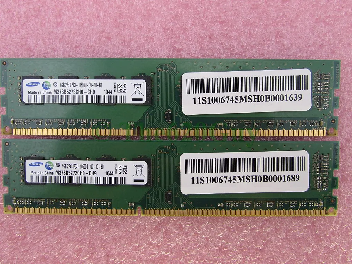 Two green rectangular circuit boards with gold edge connectors and black memory chips