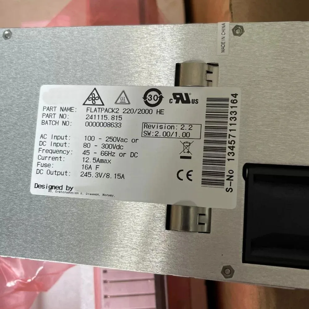Rectangular metal power supply unit with ventilation slots and label showing 245.3V 8.15A 2000W