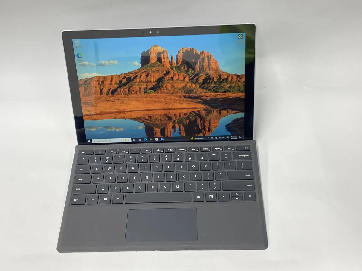 Silver 12 inch detachable tablet with kickstand and keyboard cover attached