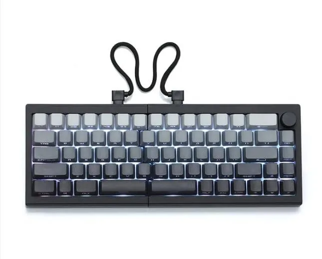 Black and white split mechanical keyboard with rotary knob and RGB lighting