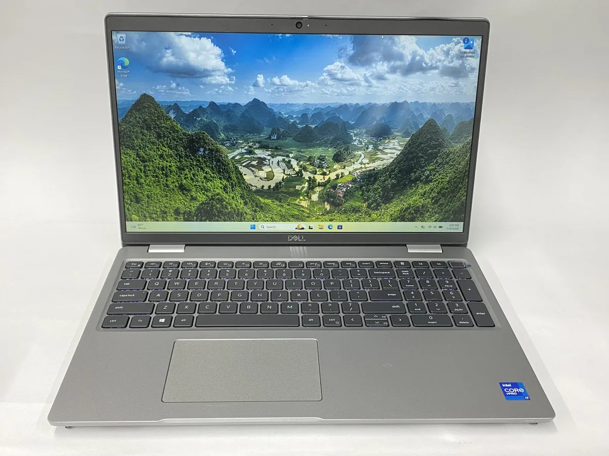 Dell Precision 3561 laptop, dark grey chassis with visible scratches and scuffs, 15.6 inch non-touch screen, charger included