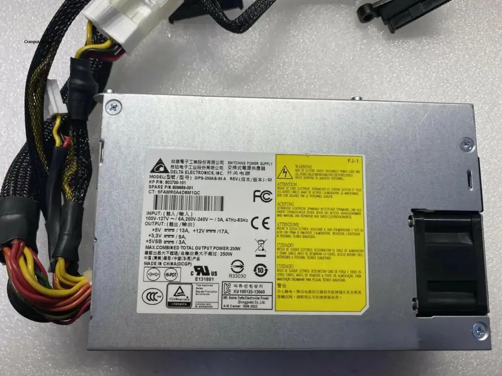 Rectangular silver ATX power supply unit with ventilation grille and label showing part numbers
