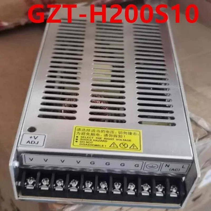Rectangular silver ATX power supply unit with ventilation grille and label showing 10V 20A 200W