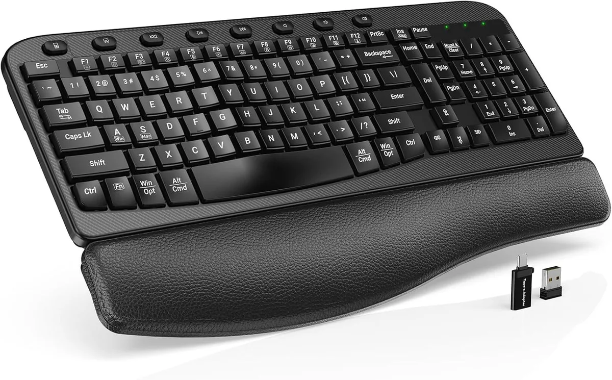 Black full-size wireless gaming keyboard with curved wave key layout and integrated cushioned wrist rest