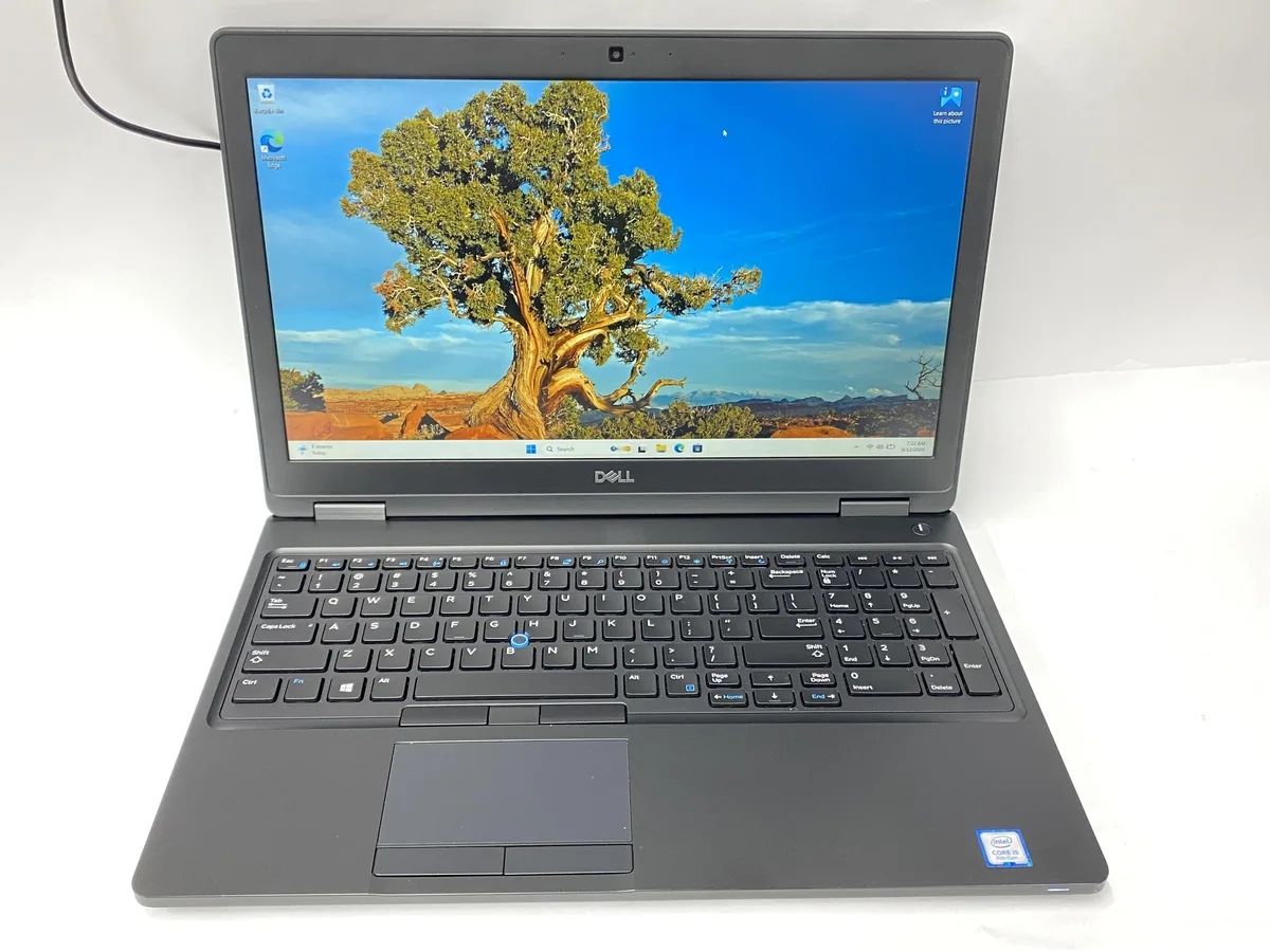 Silver Dell Latitude 5590 clamshell laptop with visible scratches and scuffs on lid and base