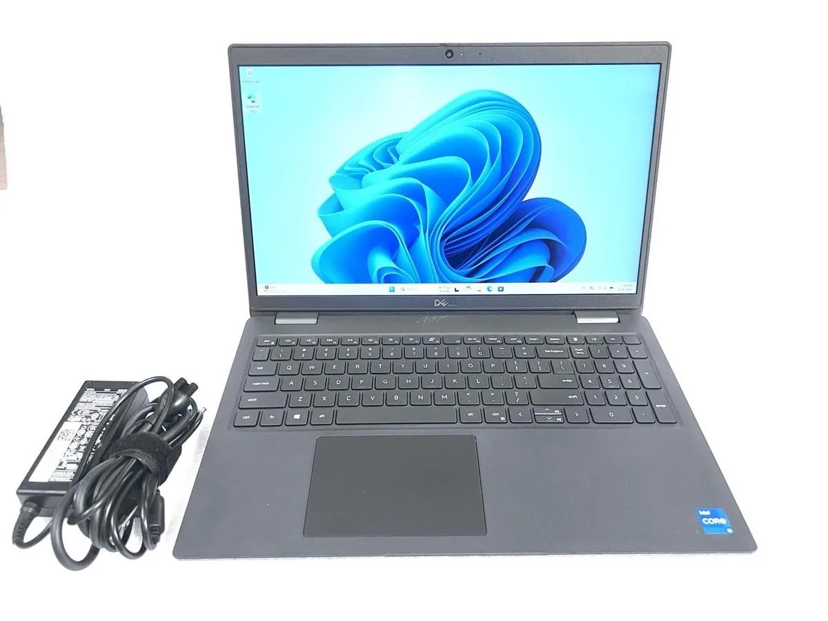 Silver Dell Latitude 3520 laptop open showing 15.6 inch screen and keyboard with visible scuff marks on casing