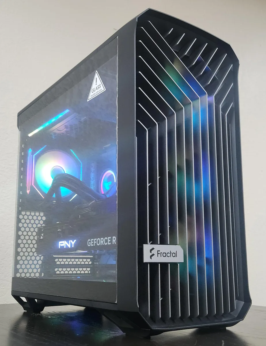Black mid-tower gaming desktop with tempered glass side panel and RGB liquid cooler