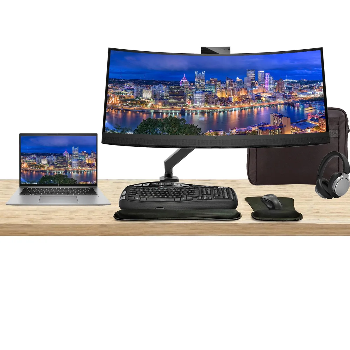 Open laptop with 14 inch touchscreen beside 34 inch curved monitor on adjustable arm, wireless keyboard, mouse