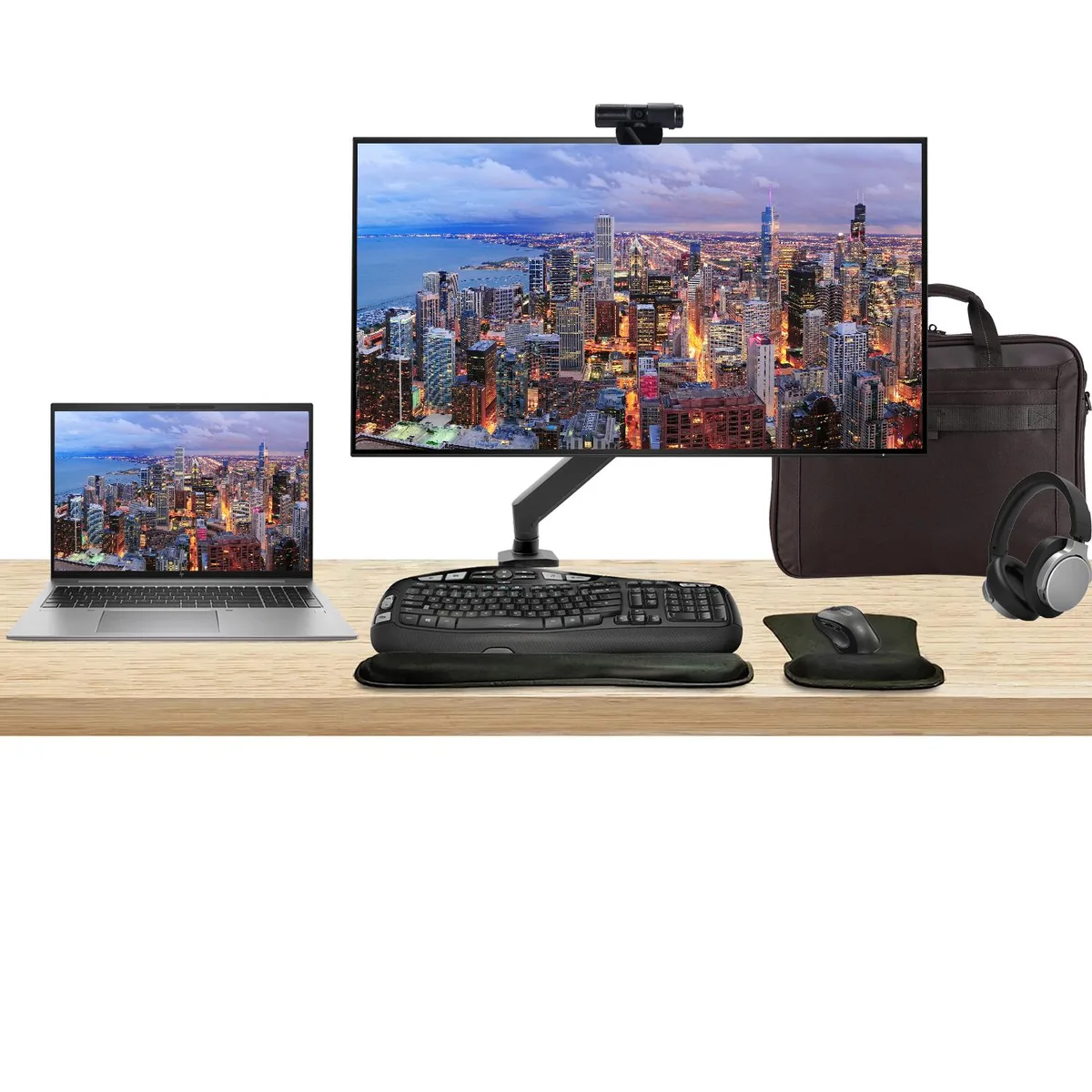 Silver laptop with 16 inch screen beside 32 inch 4K monitor on adjustable arm, wireless keyboard mouse webcam headphones and briefcase
