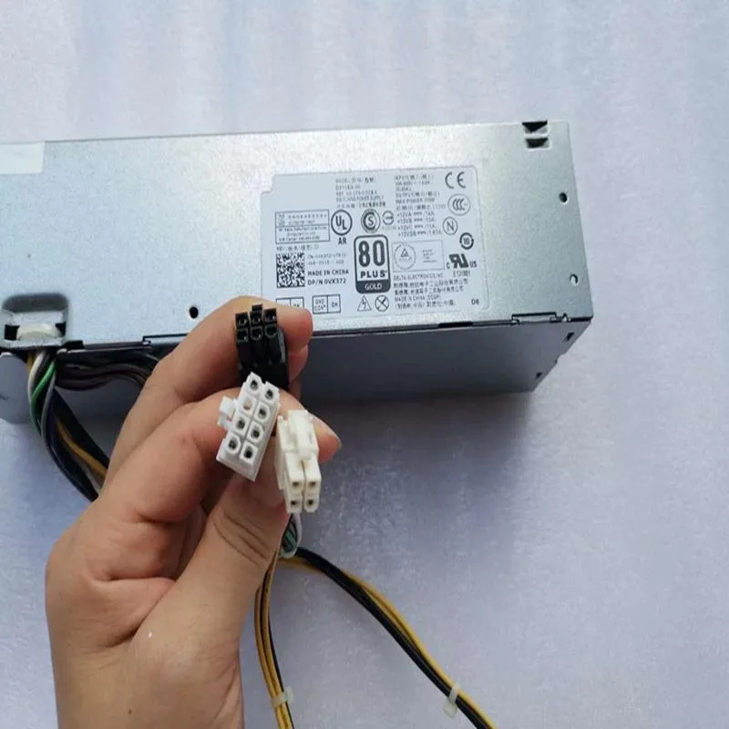 Silver metal ATX power supply unit with cooling fan grille and cable bundle