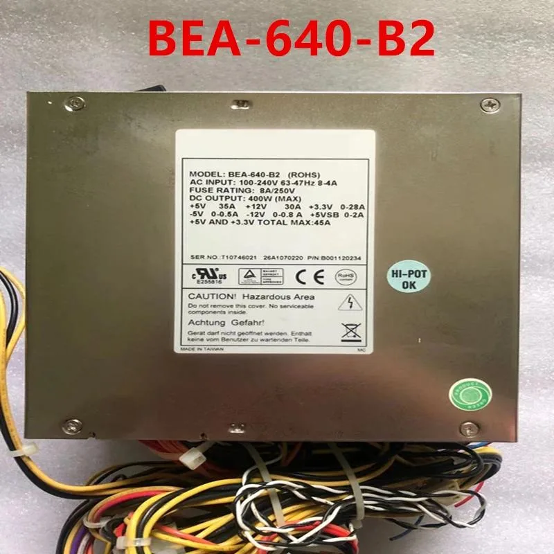 Rectangular metal ATX power supply unit with ventilation grille and cable bundle