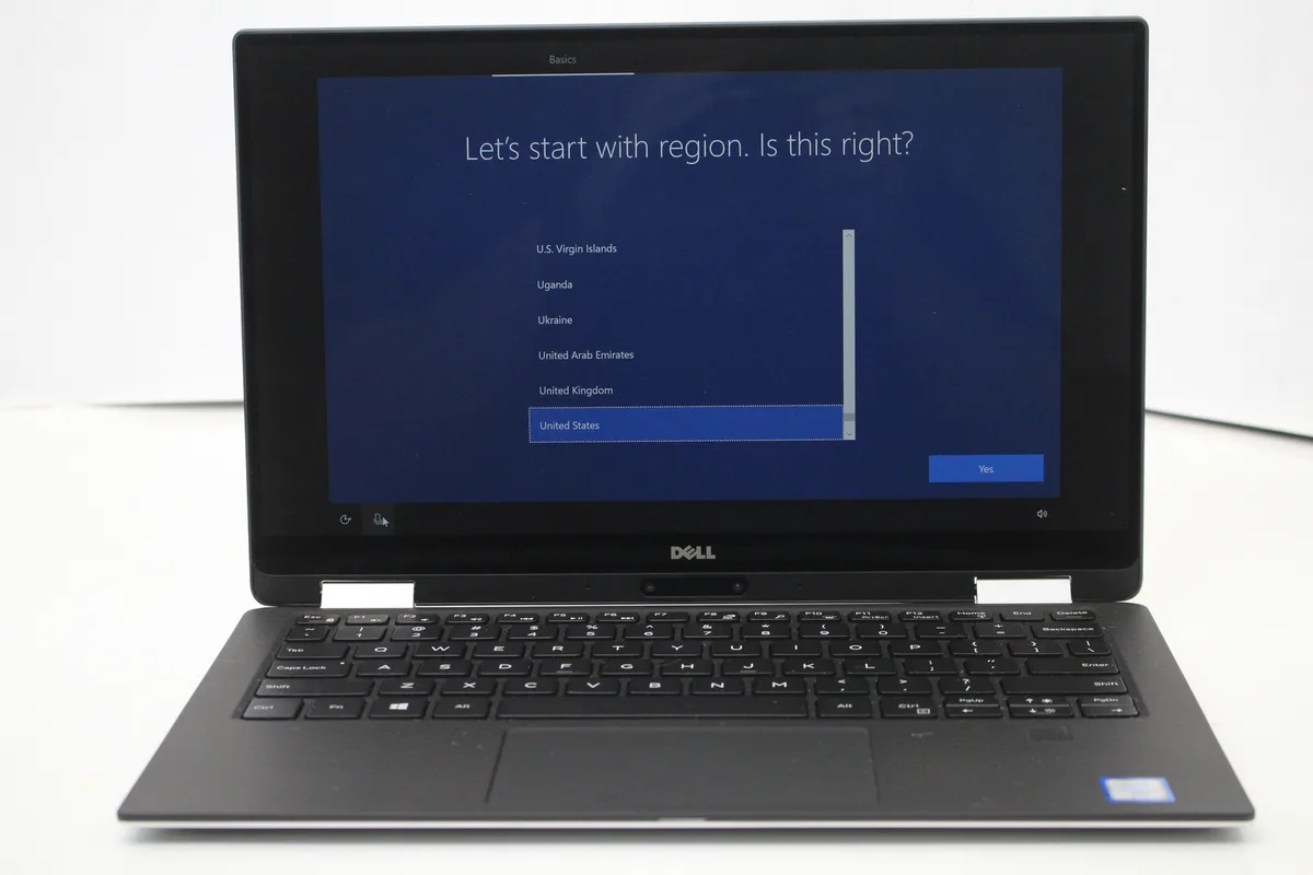 Silver 13.3-inch convertible laptop with InfinityEdge touch display, visible scratches on lid and base