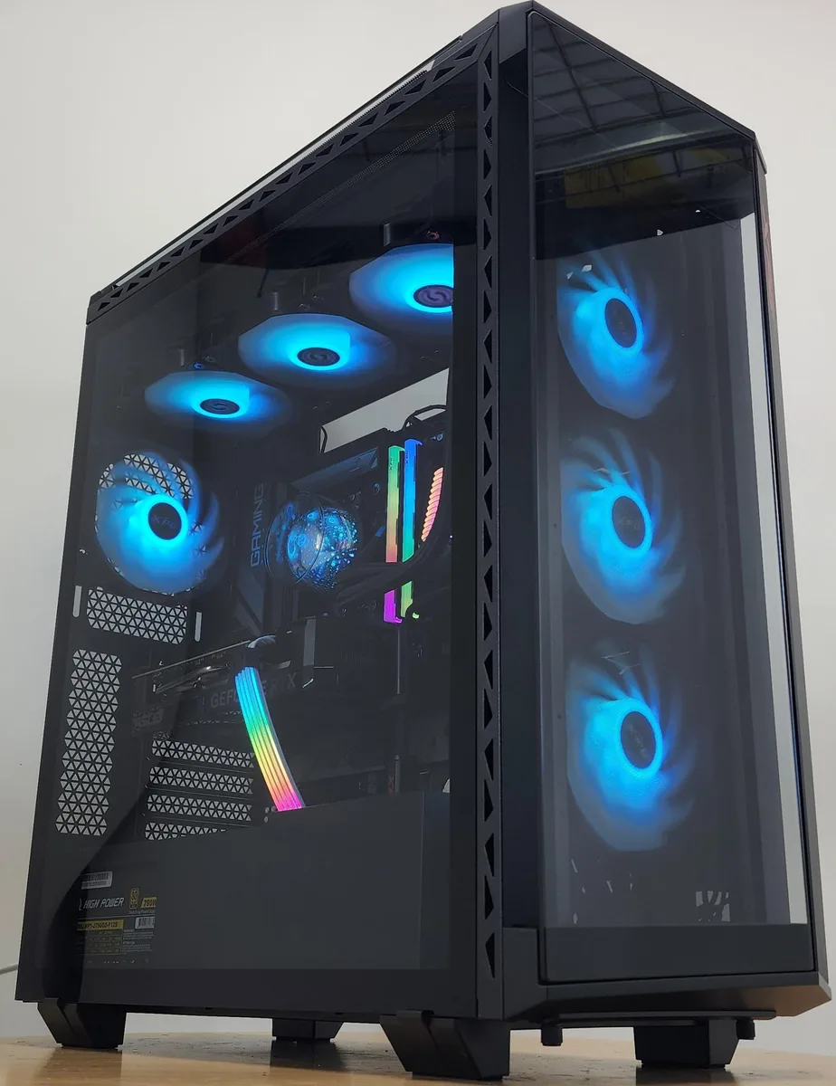 Mid-tower gaming desktop in a white XPG Battlecruiser case with RGB liquid cooling visible through tempered glass side panel