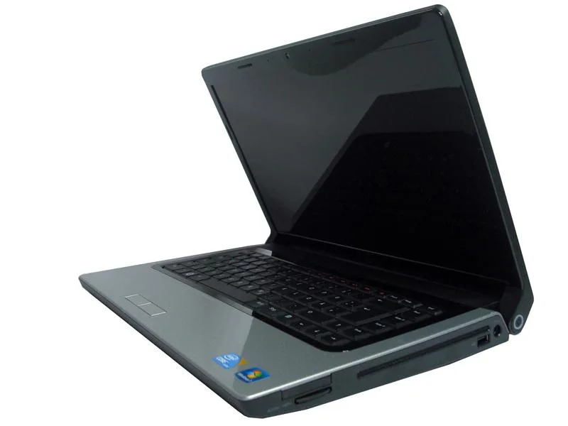 Silver Dell Studio 1557 laptop open showing 15.6 inch screen and keyboard with scratched lid