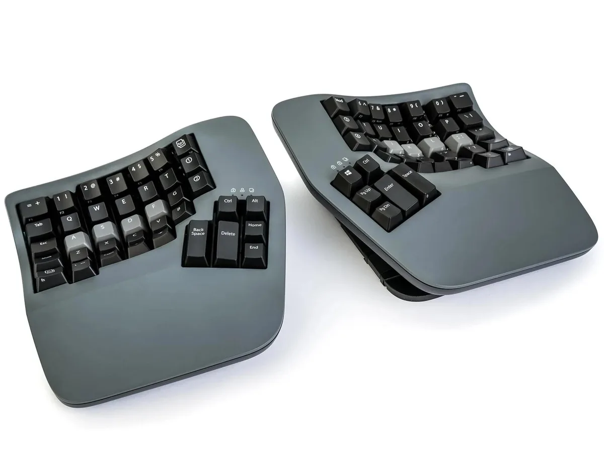 Dark gray split keyboard, two concave key wells, integrated tenting legs, palm supports, wireless or wired, 76 keys per module