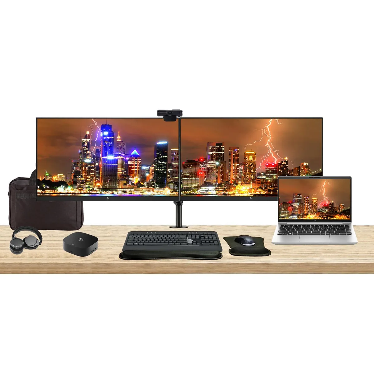 Silver 14-inch laptop with dual 27-inch monitors on adjustable stand, USB-C dock, wireless keyboard, mouse, webcam, headphones