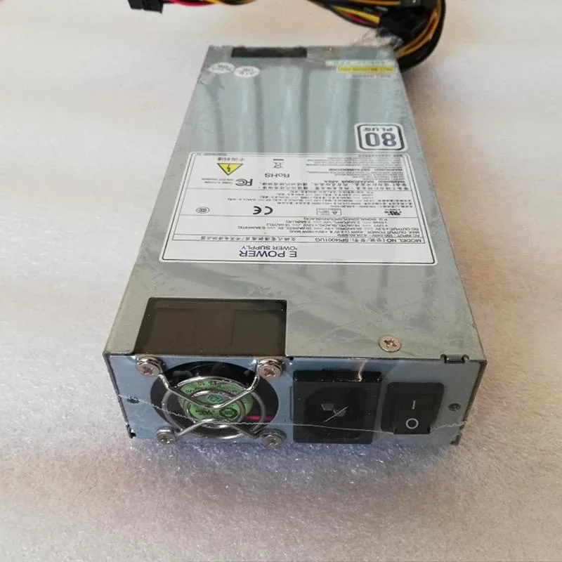 Compact 1U silver power supply unit with rear fan grille and modular cable connectors