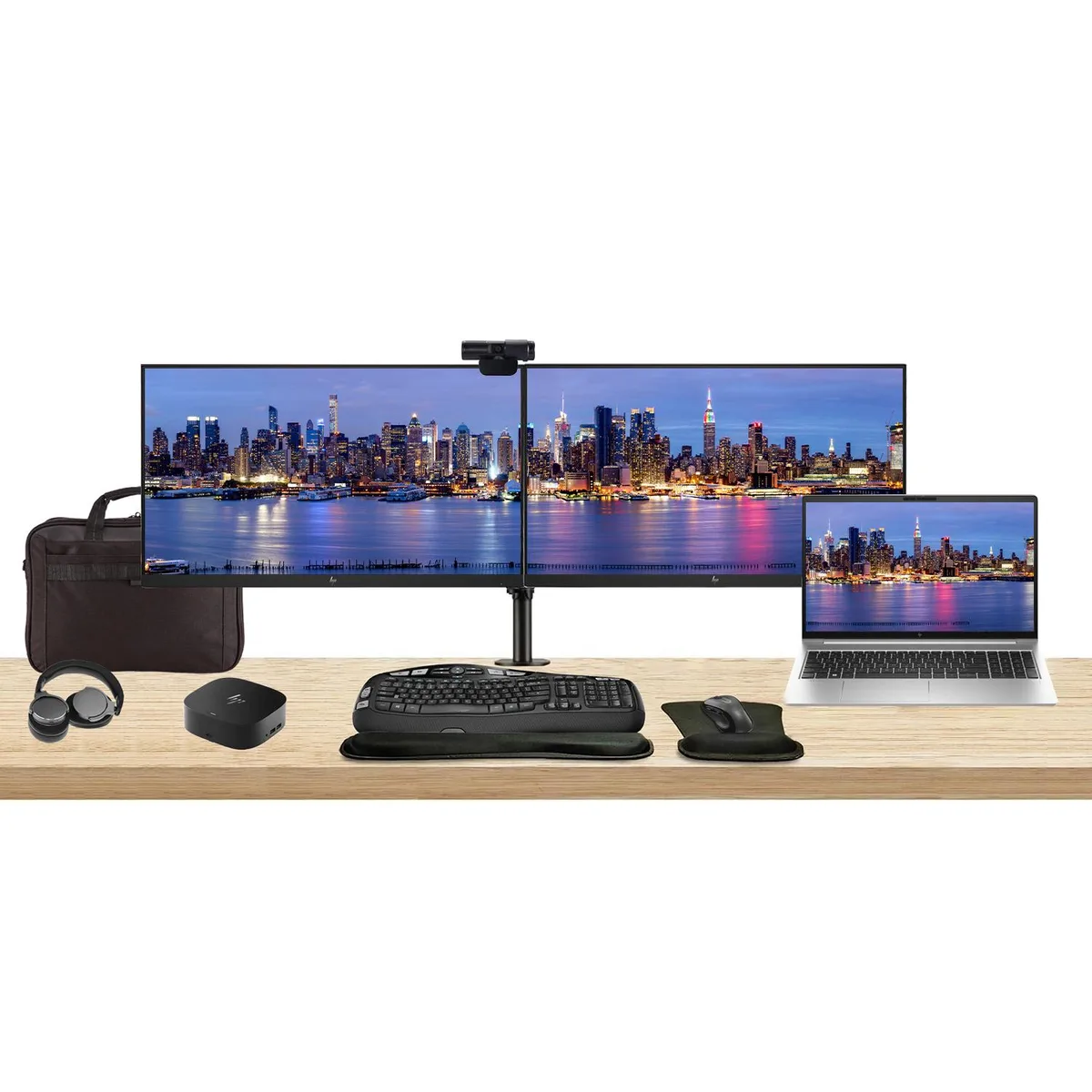 Open laptop with touchscreen beside two monitors on a shared stand, dock, keyboard, mouse, webcam, headphones and briefcase