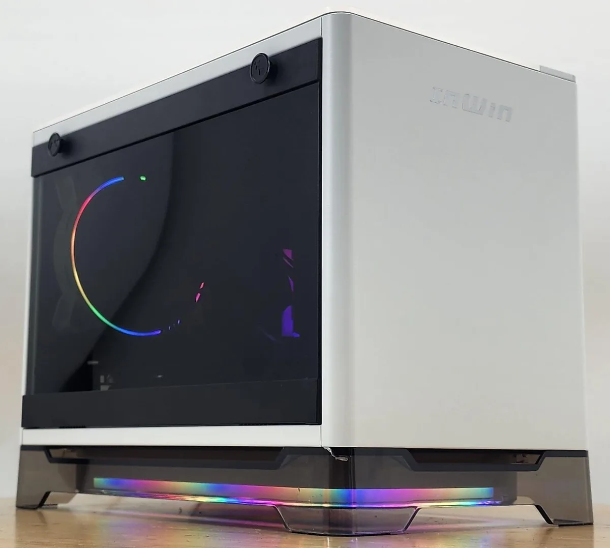 White compact tower with glass side panel showing RGB-lit AIO cooler, graphics card and memory