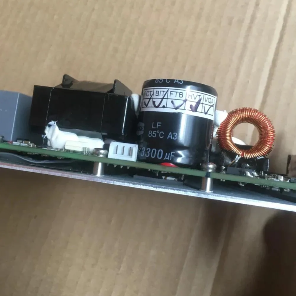 Green circuit board with silver heatsinks and soldered components