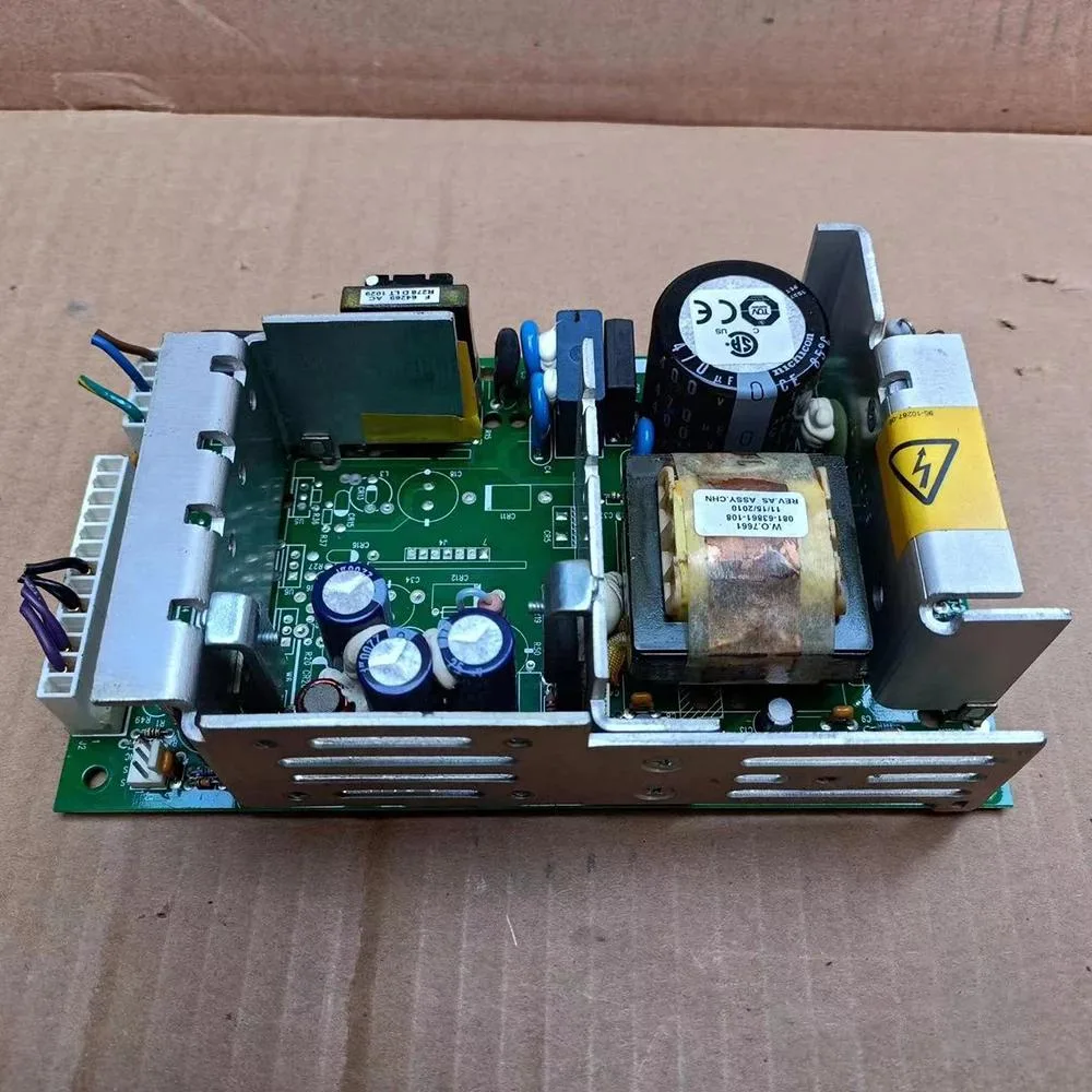 Rectangular silver power supply module with label showing 12V 10A 15V 8A