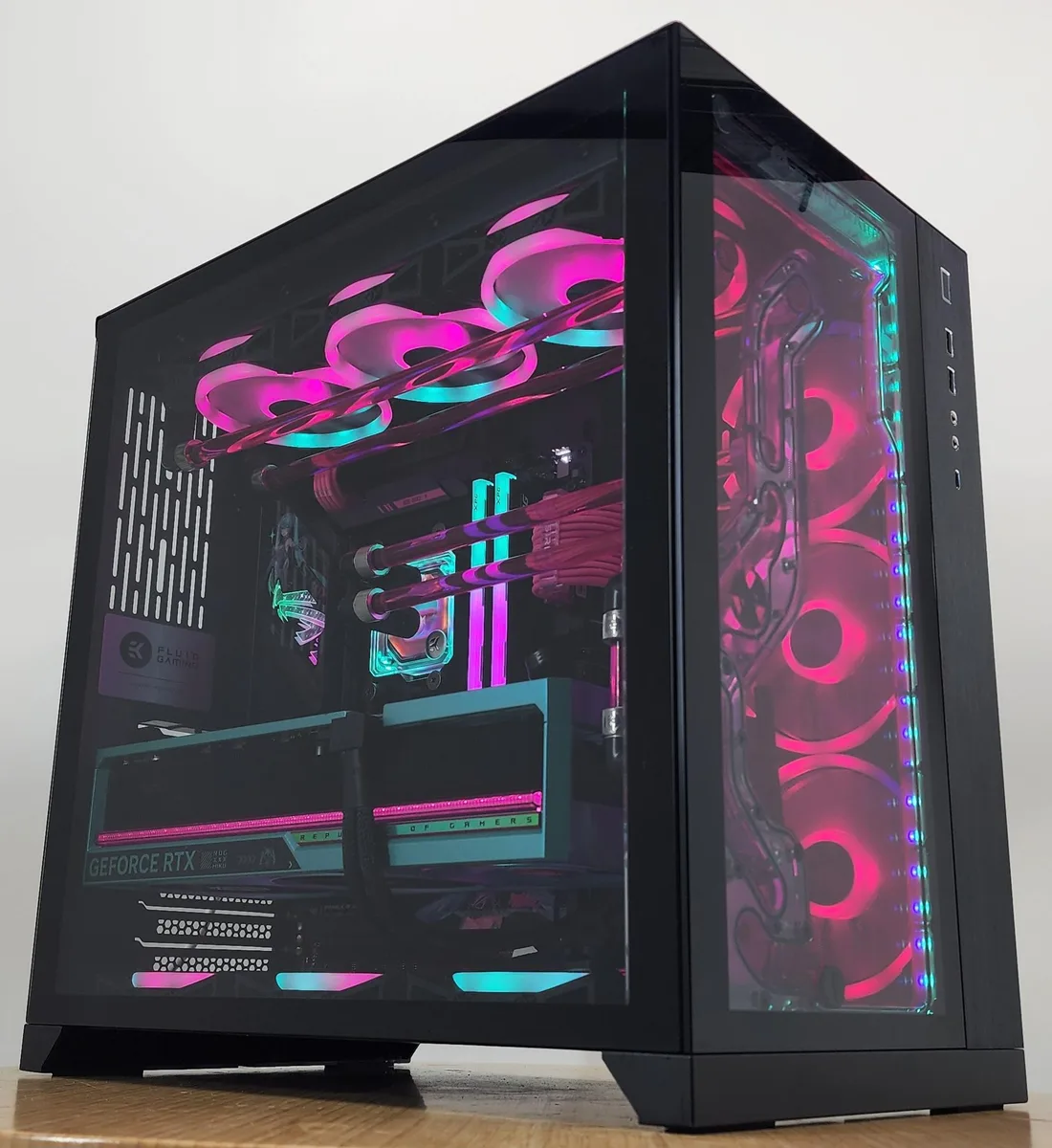 Black Lian Li O11 Dynamic ATX case with tempered glass panels showing EK water block, RTX 5080 graphics card and RGB DDR5 memory