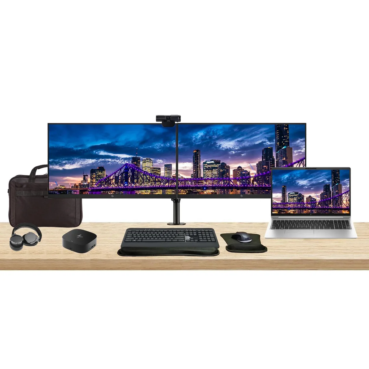 Silver 15.6 inch laptop beside two 24 inch monitors on a dual desk stand with dock keyboard mouse webcam headphones wrist rest