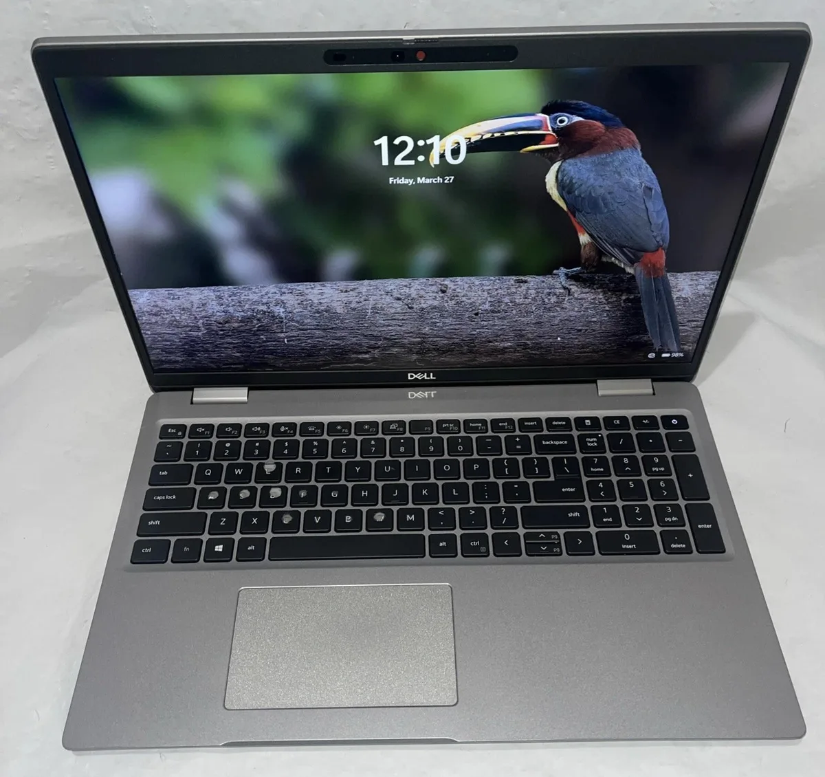 Silver Dell Latitude 5520 laptop open showing worn keyboard keys and 15.6 inch screen