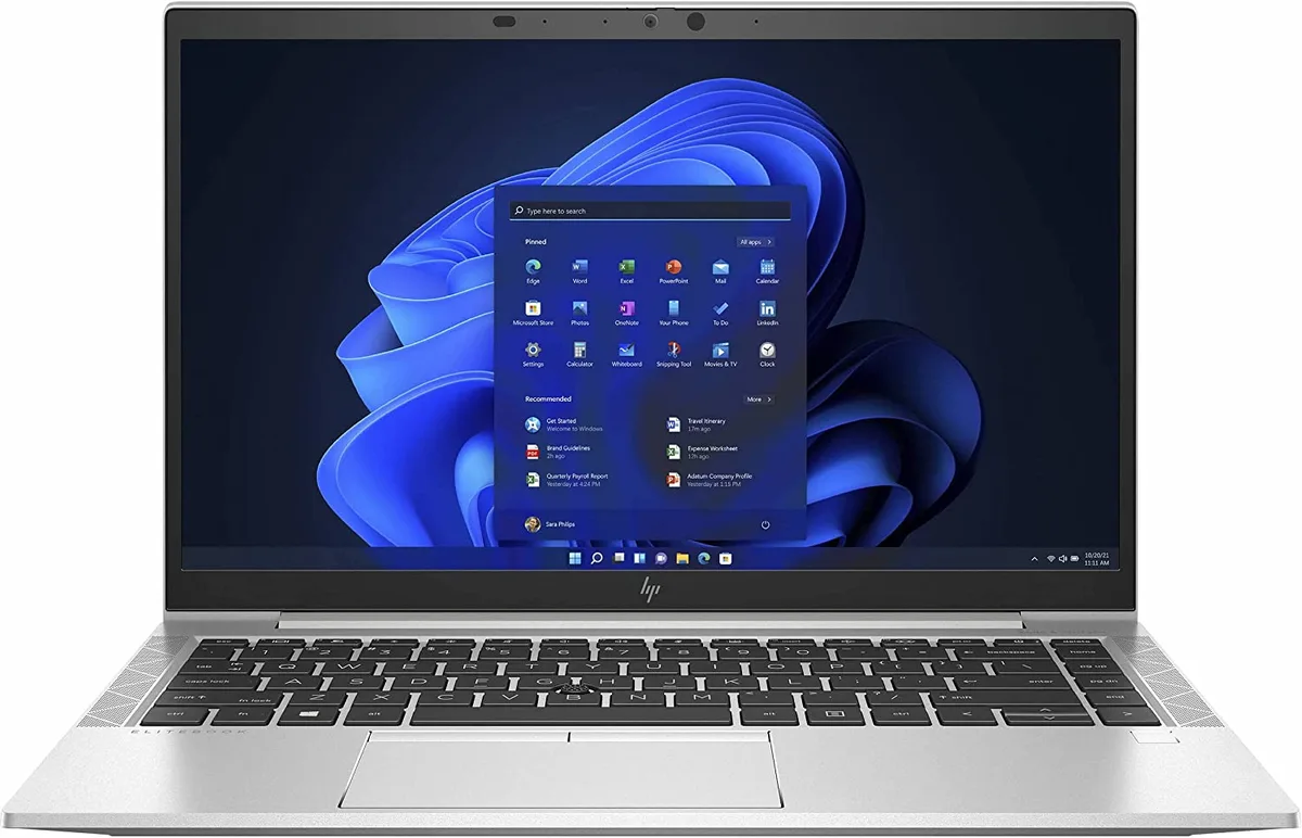 Silver 14-inch business laptop, closed lid, power adapter beside it