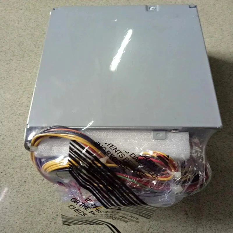 Black rectangular ATX power supply unit with cooling fan visible through metal grille and power connector socket on rear
