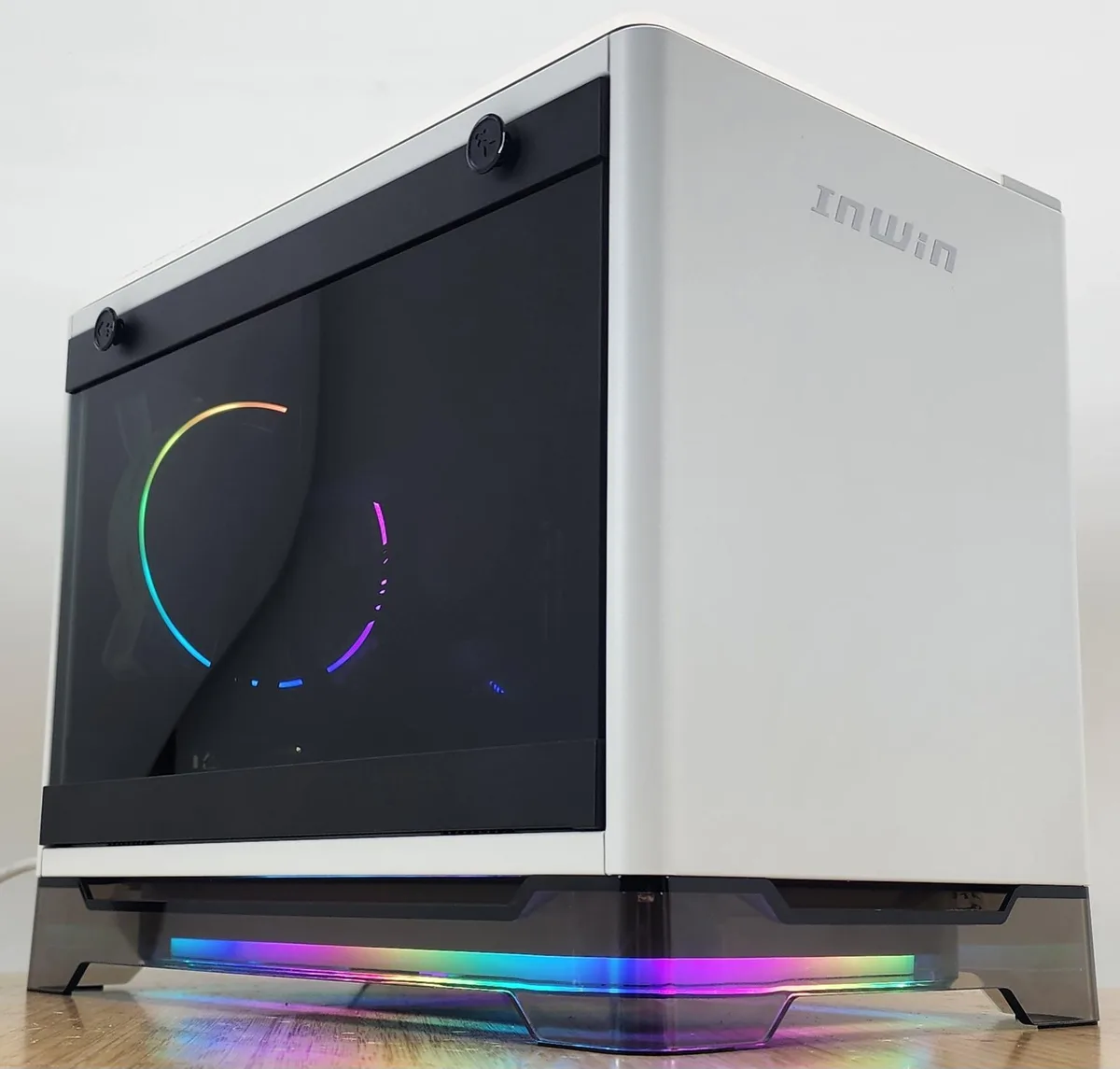 White compact ITX tower with side glass panel showing AIO cooler and graphics card