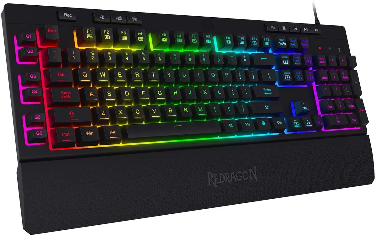 Black membrane gaming keyboard with RGB backlighting, six macro keys, media controls, and magnetic wrist rest