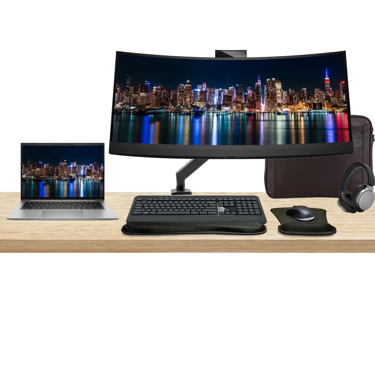 A silver 14-inch laptop beside a curved 34-inch monitor with webcam, wireless keyboard, mouse, headphones and briefcase