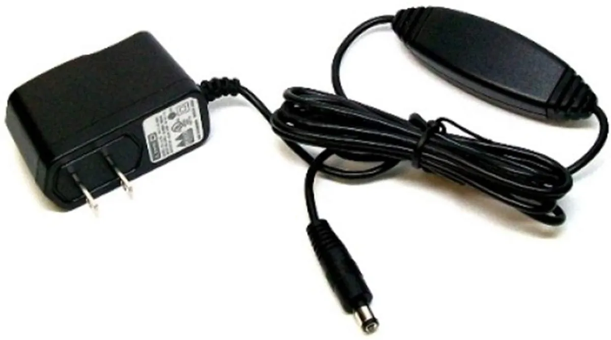 Black rectangular wall-wart power adapter with fixed AC prongs and a thin DC cable ending in a 2.1 mm barrel plug