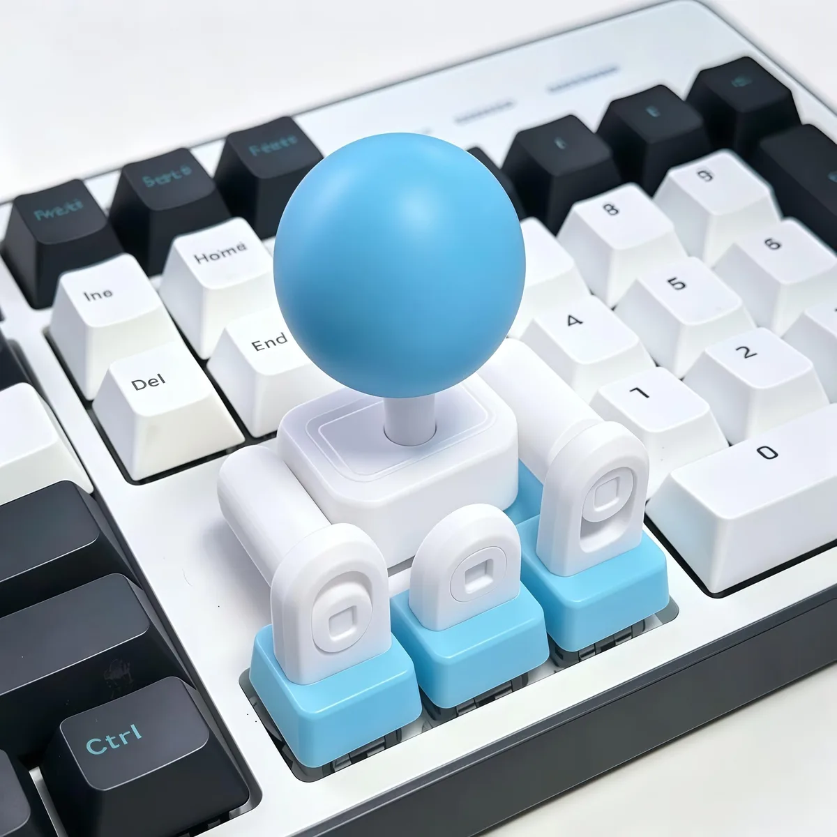 3D-printed blue-white joystick adapter with four keycap linkages and three coloured ball tops