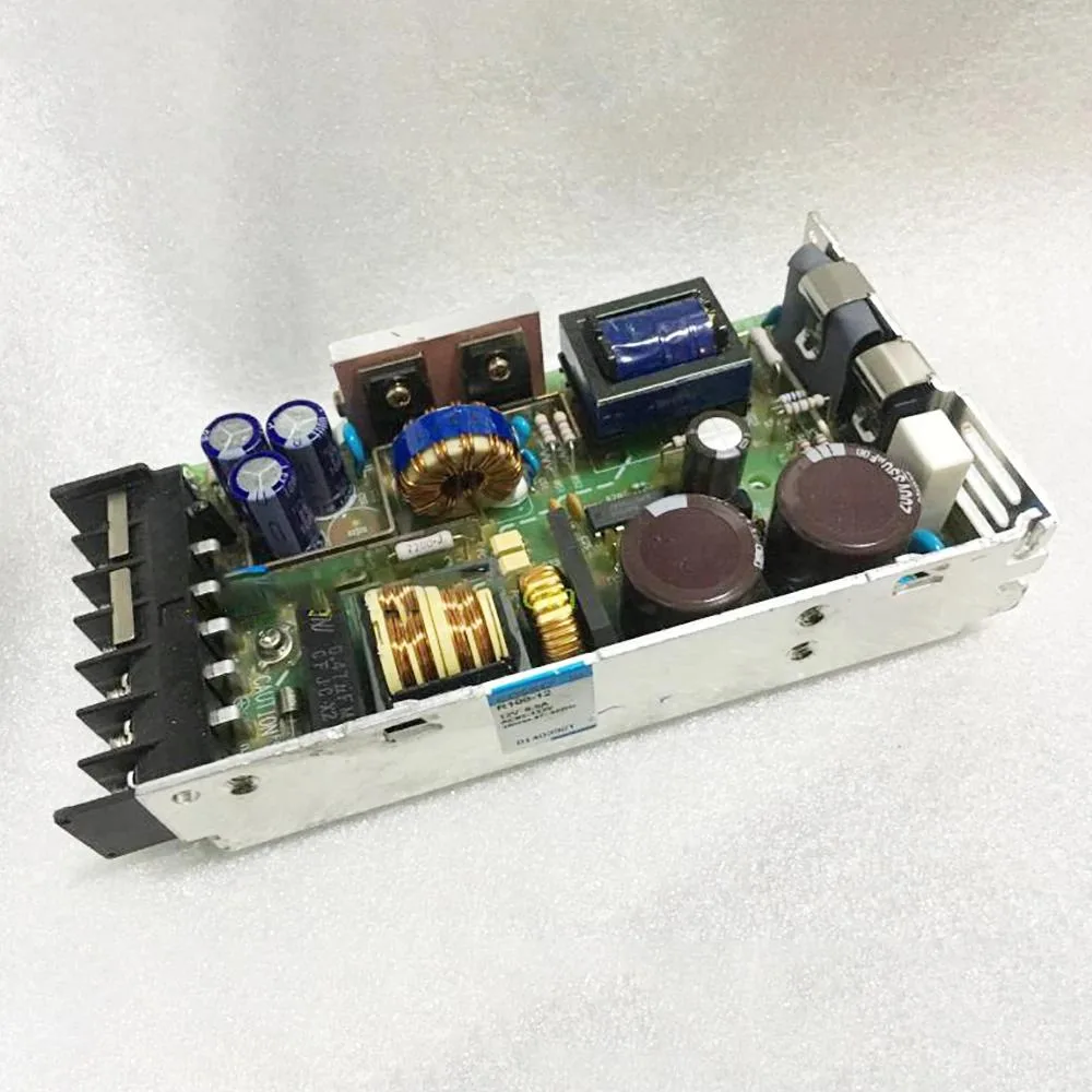 Rectangular metal power supply unit with ventilation slots and label showing 12V 8.5A specifications