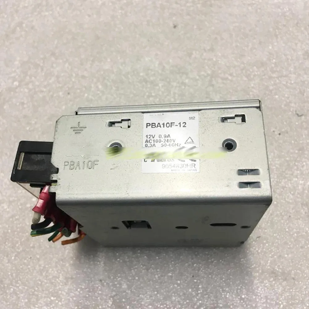 Small black rectangular ATX power supply unit with label showing 12V .9A