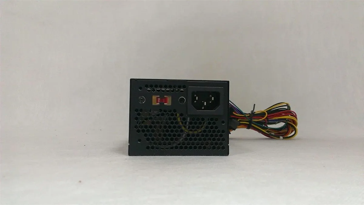 Compact TFX power supply unit, metal casing, 80mm fan grille, multiple cable connectors visible