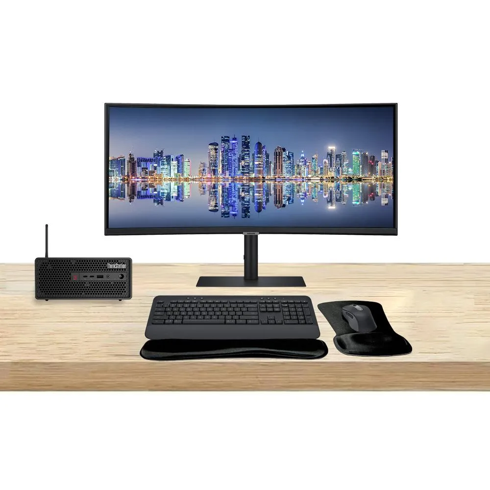 Small black tower workstation beside a wide curved 49-inch monitor with wireless keyboard and mouse