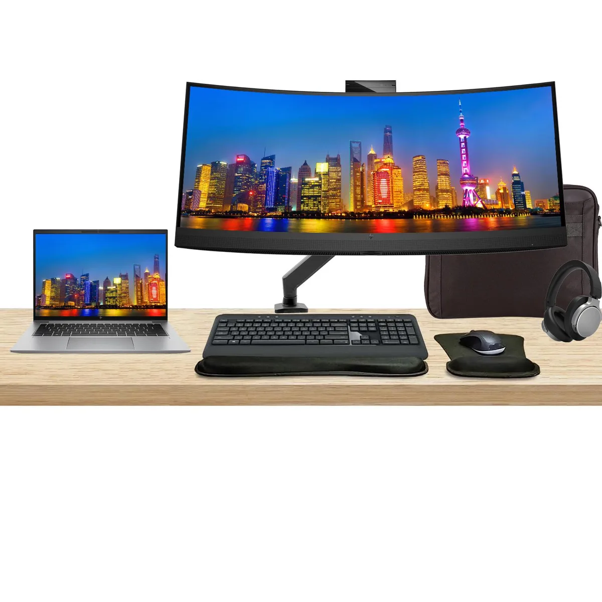 A 14 inch silver laptop, 34 inch curved monitor, wireless keyboard, mouse, headphones, briefcase and desk mount