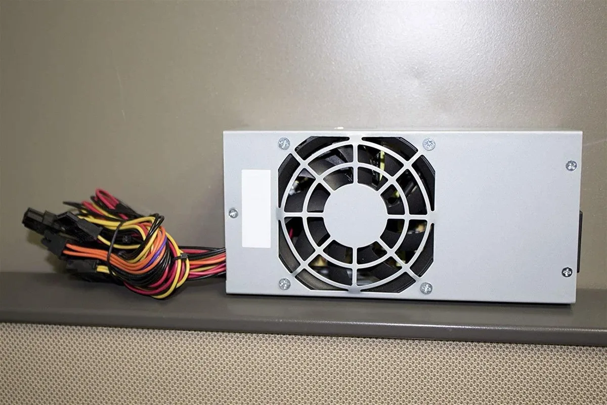 Compact silver TFX power supply unit with rear fan grille and cable bundle