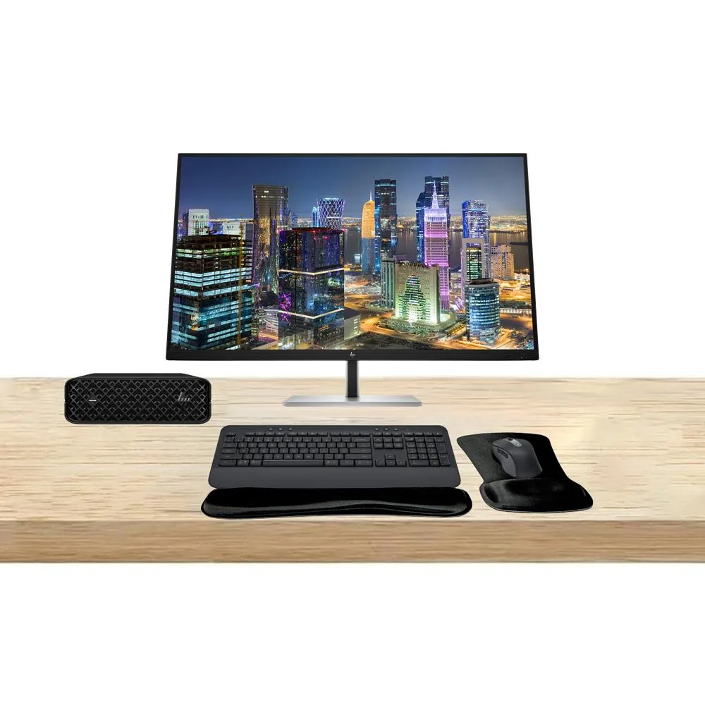 Compact silver mini PC with two large black 4K monitors, wireless keyboard and mouse