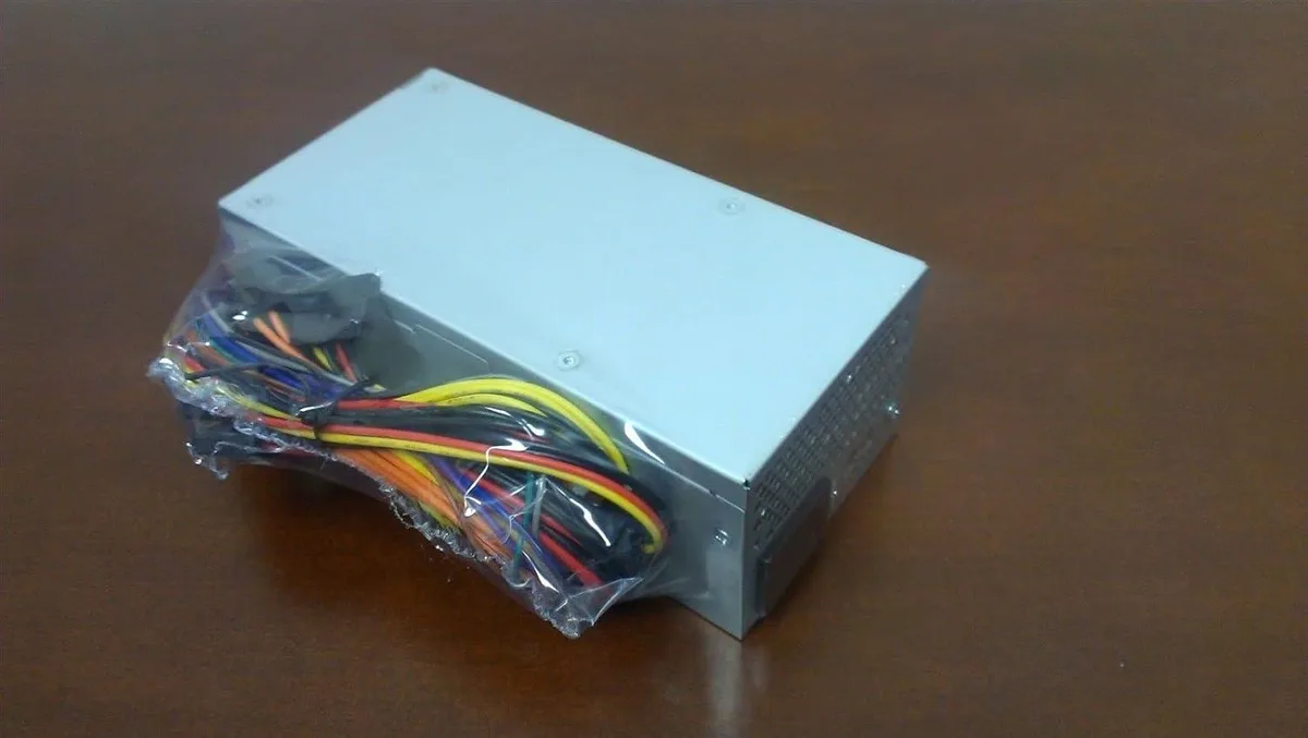 Compact TFX power supply unit, matte metal casing, rear fan grille, side label, cable bundle emerging