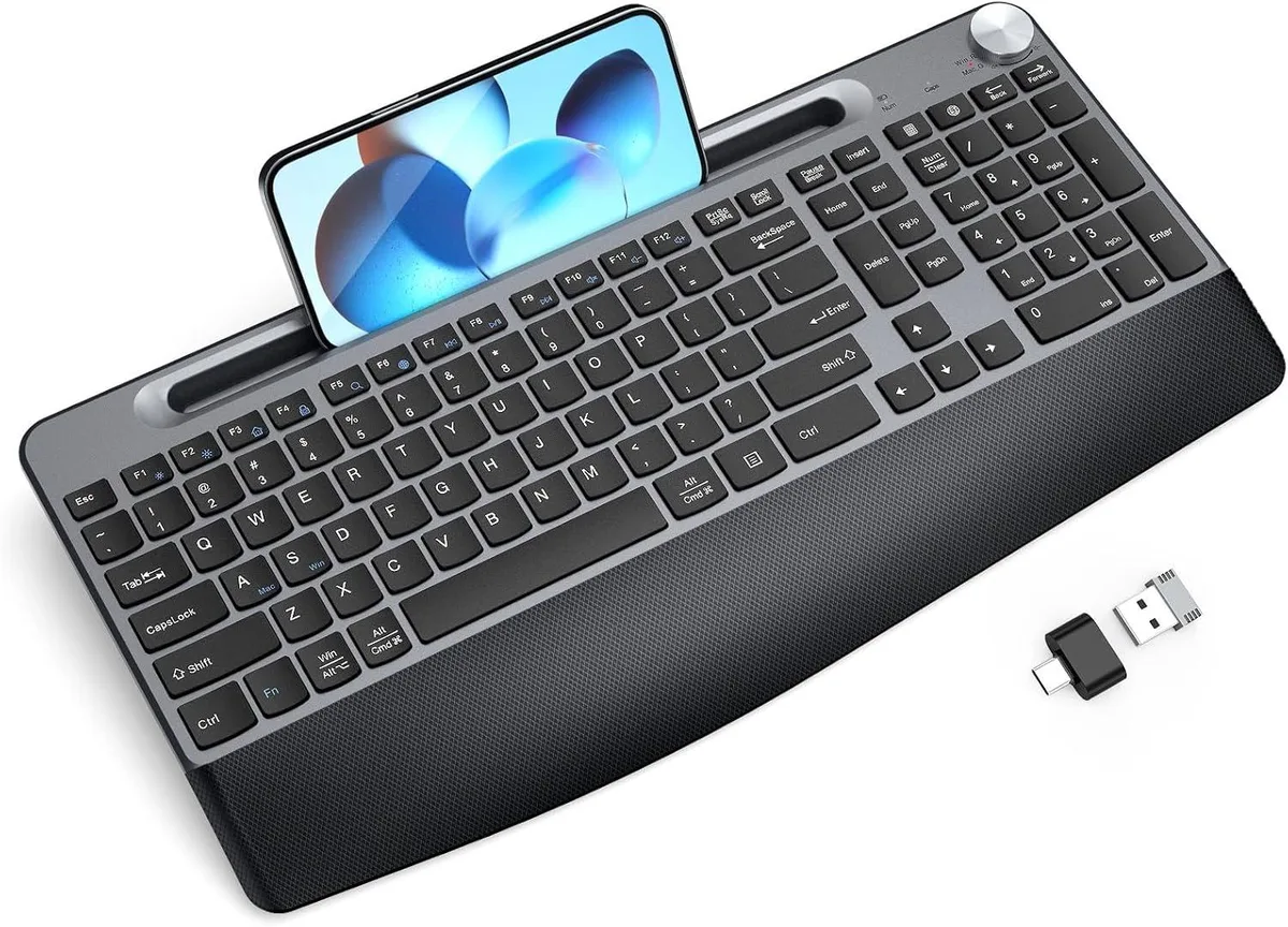 Black full-size wireless gaming keyboard with integrated wrist rest and phone or tablet holder slot